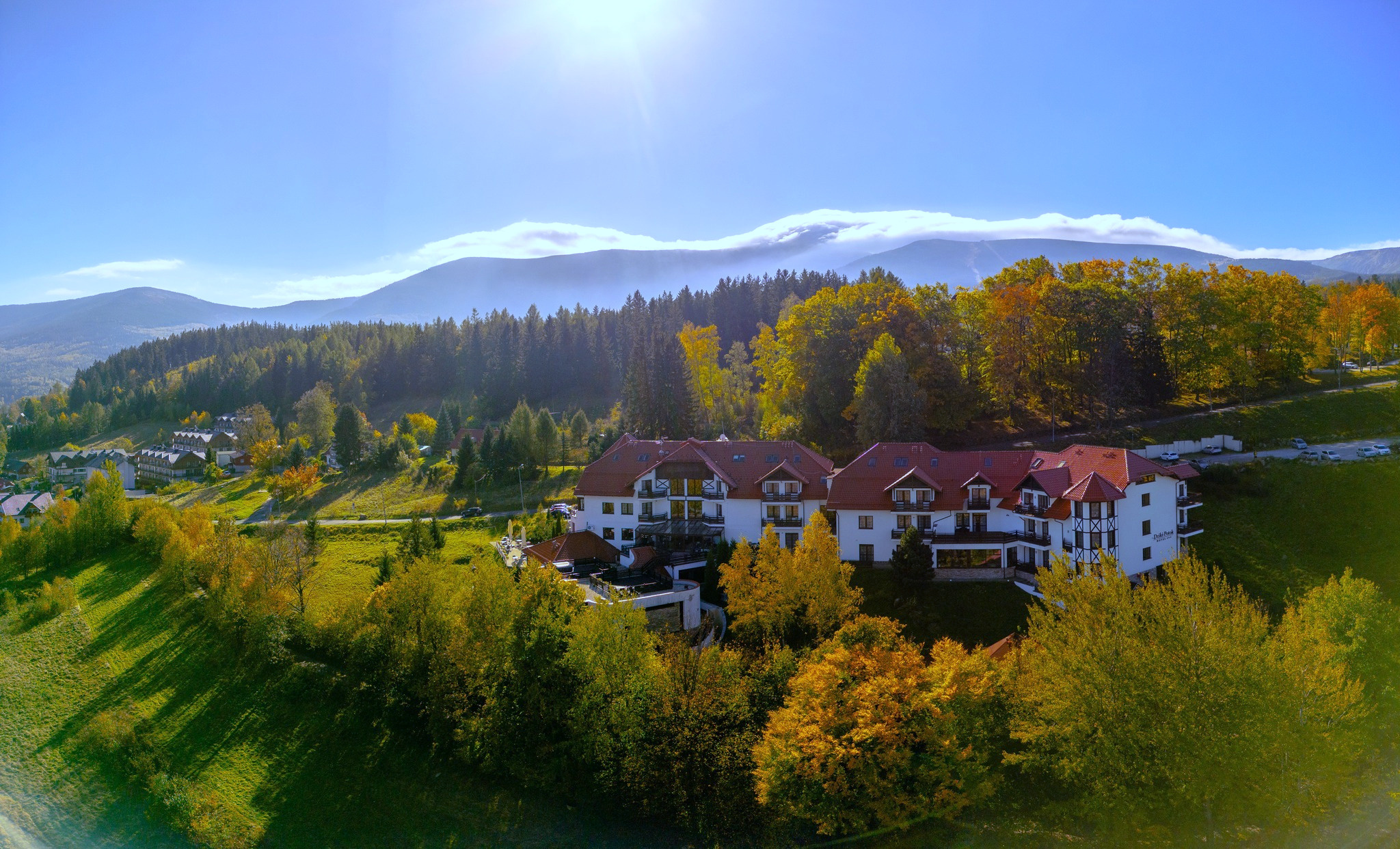 Hotel Dziki Potok z Lotu ptaka - w tle widać śnieżkę skąpaną w chmurach w piękny, słoneczny dzień
